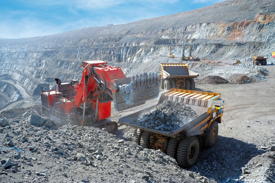 A truck picking up iron ore at a mine. A truck picking up iron ore at a mine.