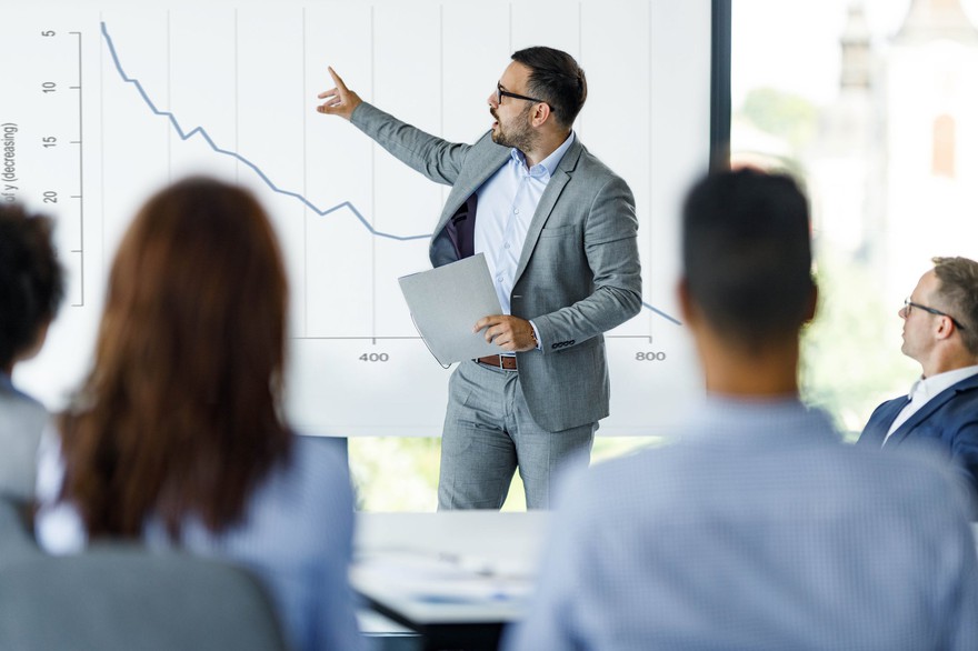 Man pointing at downtrending line.