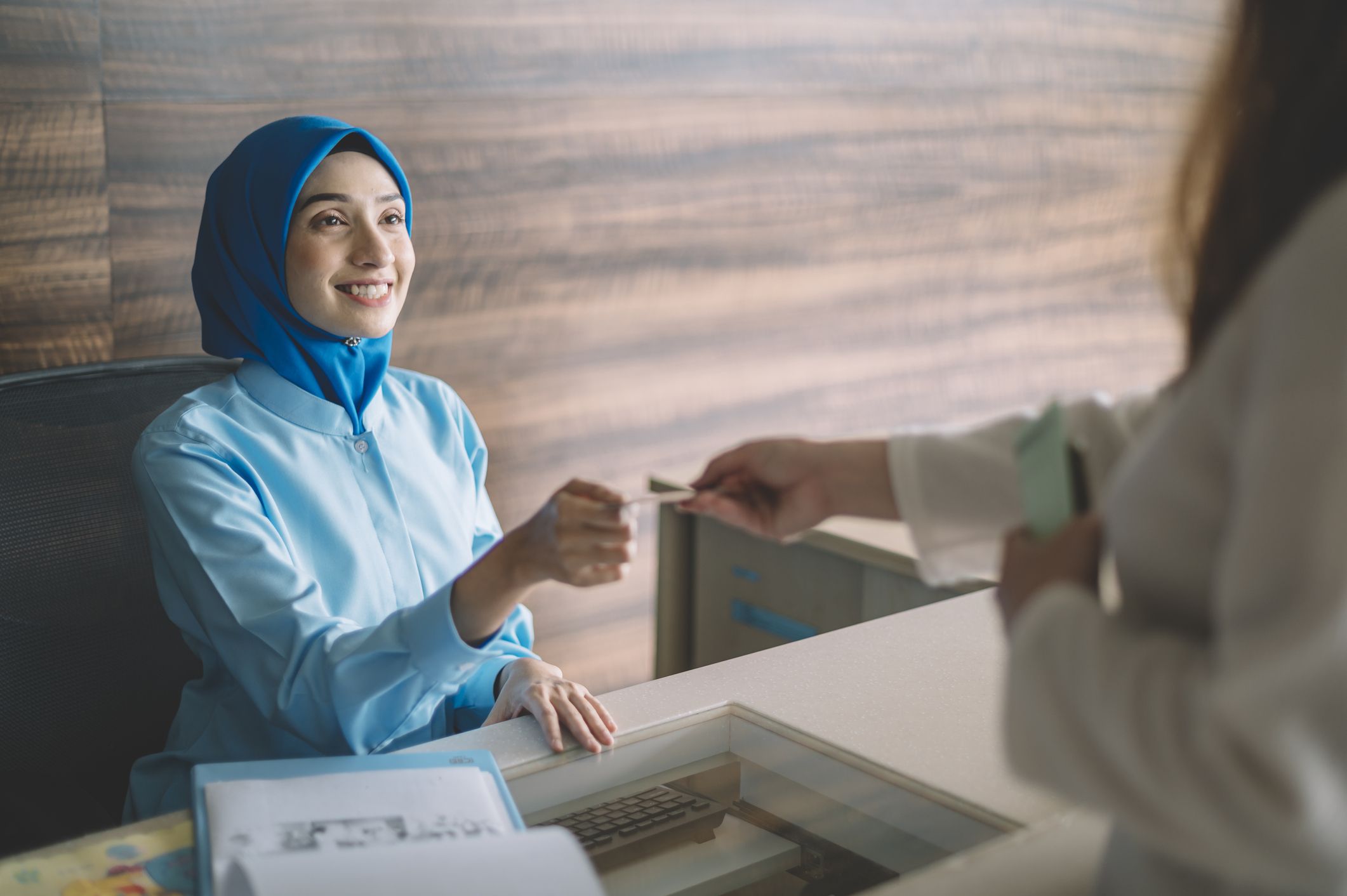 Person pays at medical office with debit card.