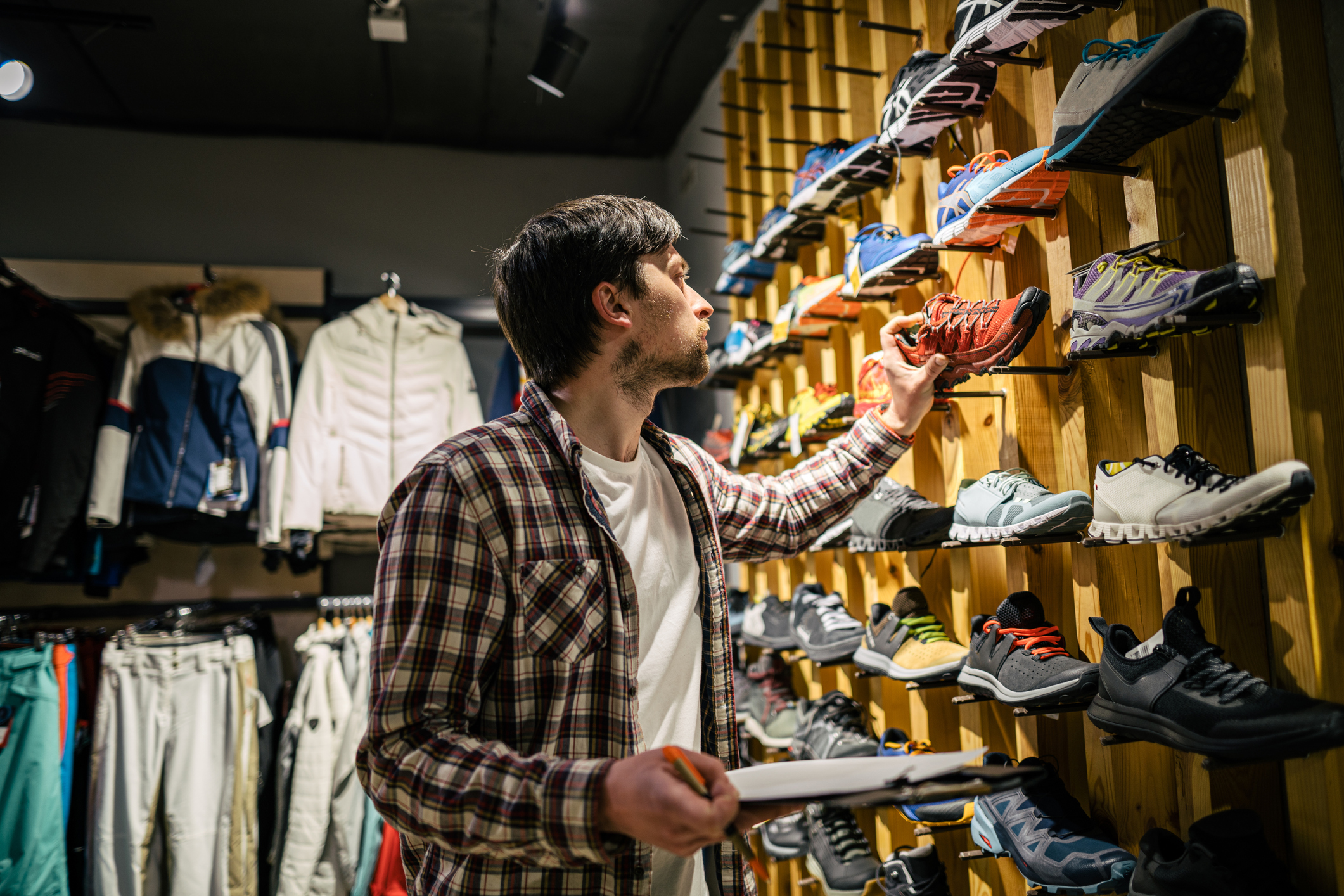 retail shoe inventory person A person with a clipboard doing inventory in a retail shoe store.