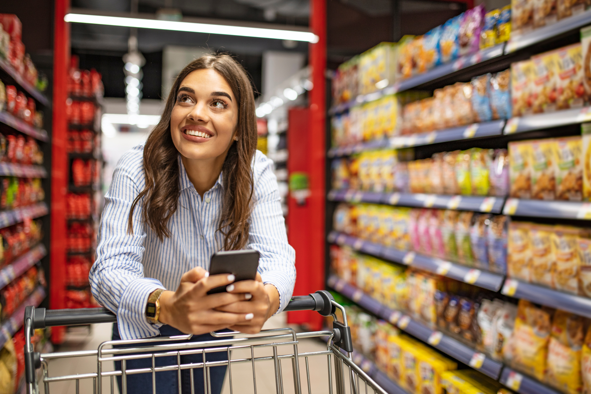 shopping grocery store sales meal prep-1200x800-5b2df79 Smiling shopper pushing cart up grocery aisle.