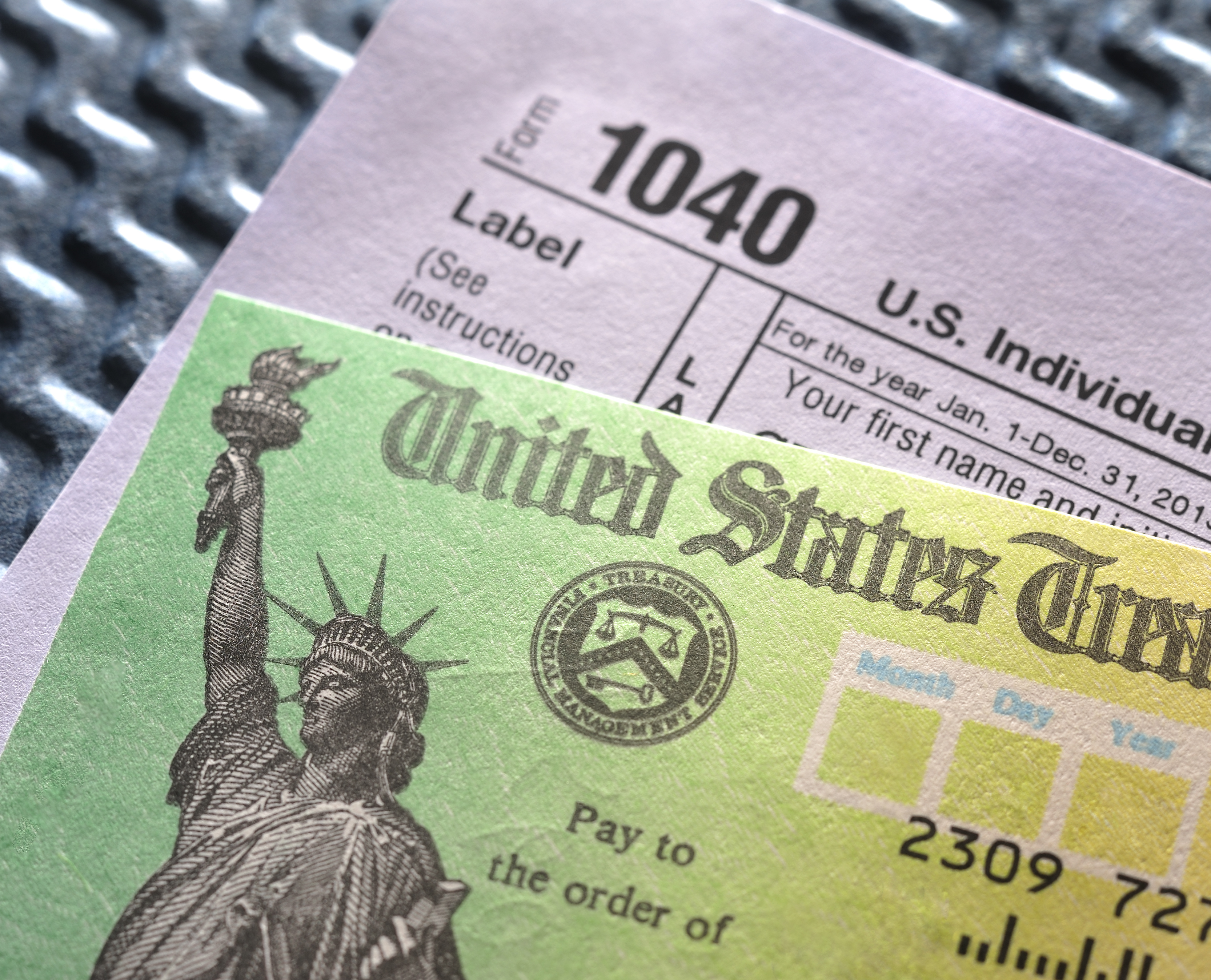 A 1040 form and tax refund check. A 1040 form and tax refund check.