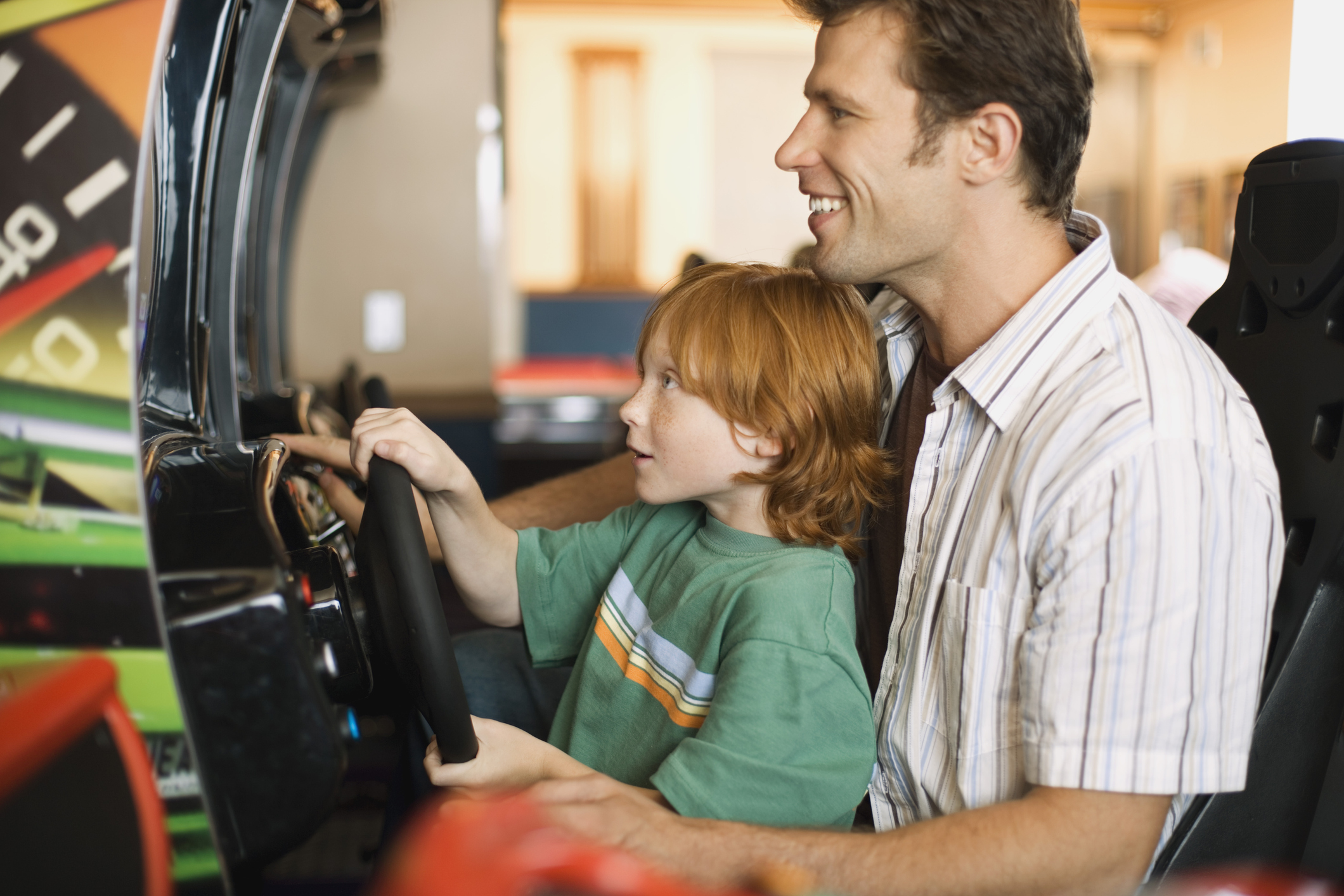 father and son playing arcade game