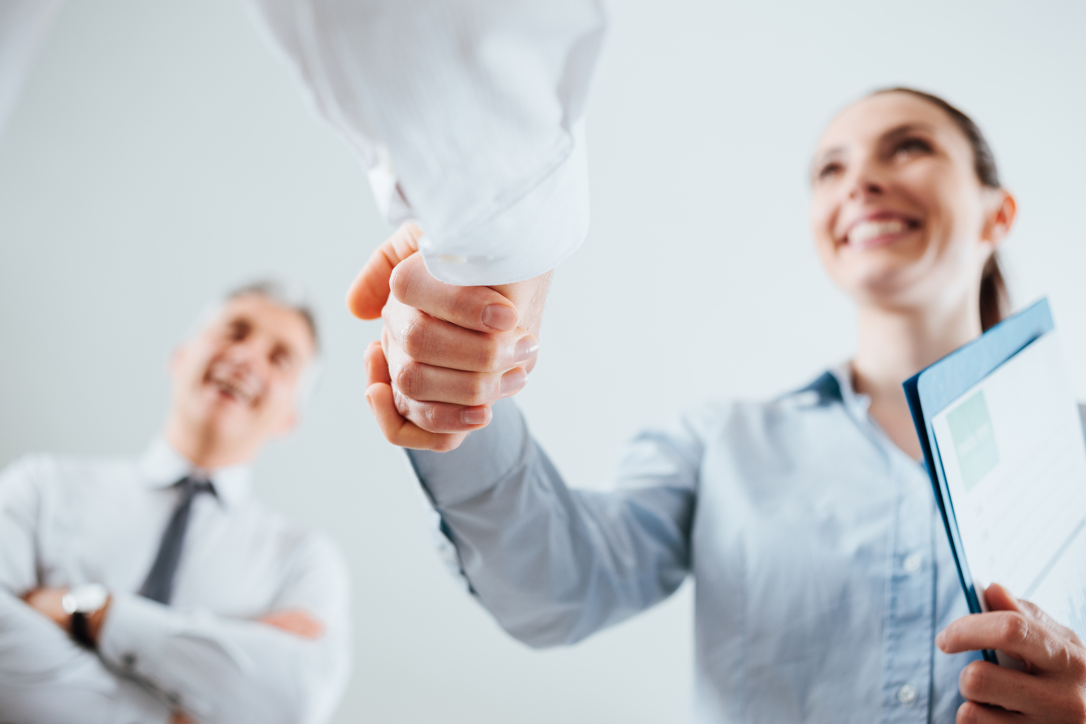 Smiling woman shaking hands with unseen person.