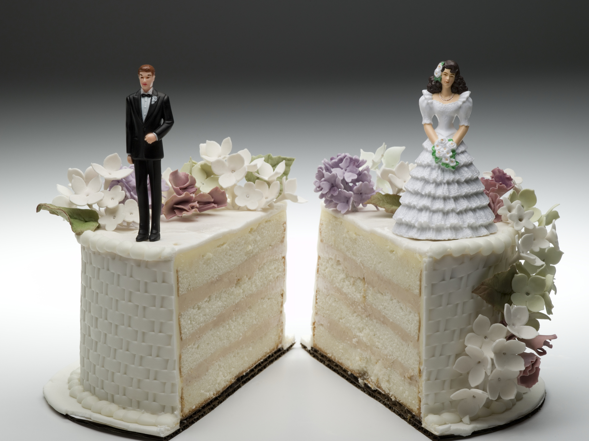 split wedding cake Wedding cake split into two pieces, with the bride on one side and the groom on the other.