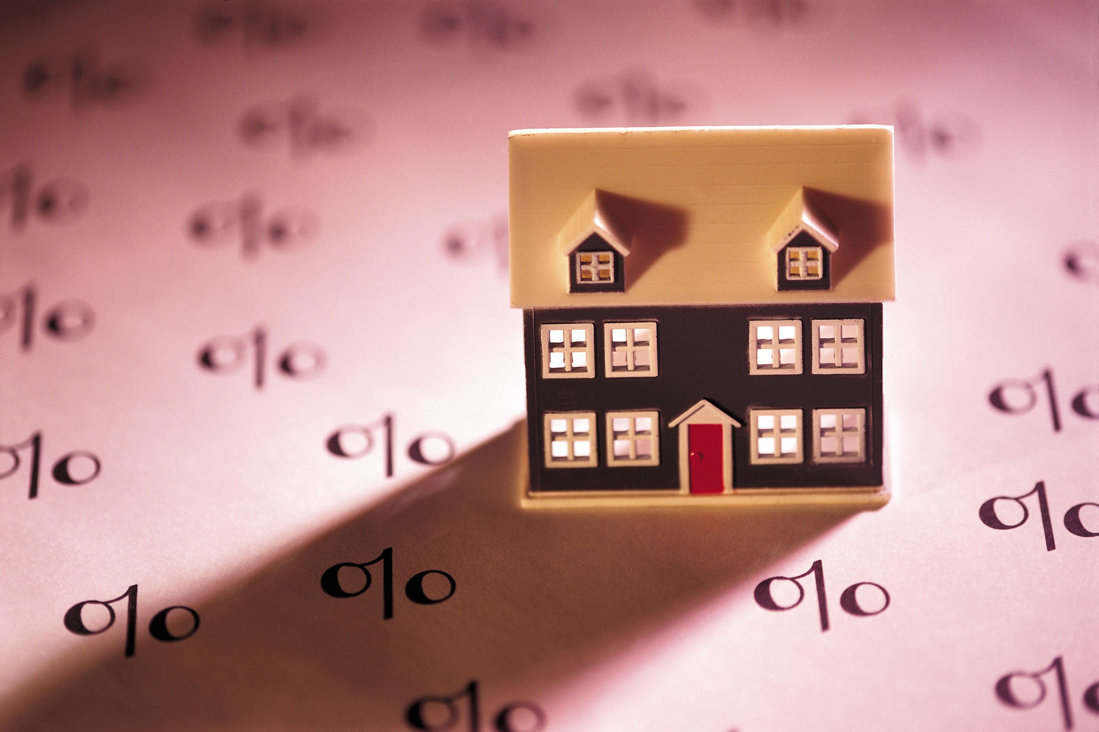 toy house on paper with percentage symbols mortgage interest rate