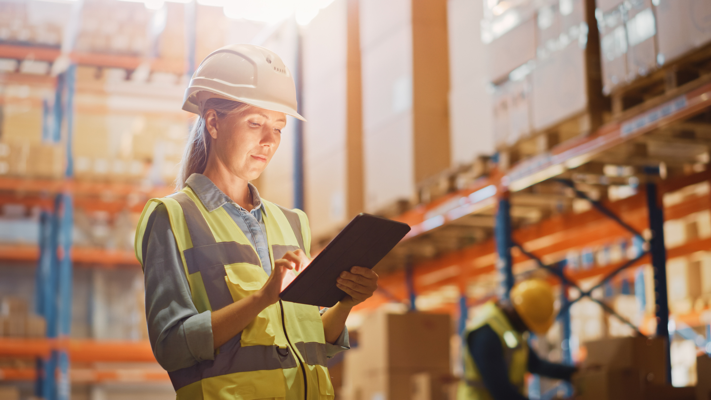 warehouse person with tablet Person standing in warehouse and holding a tablet.