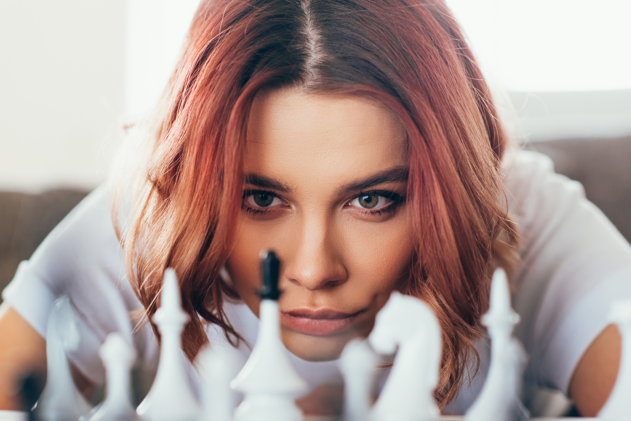 Woman playing chess and thinking. Person playing chess and contemplating next move.