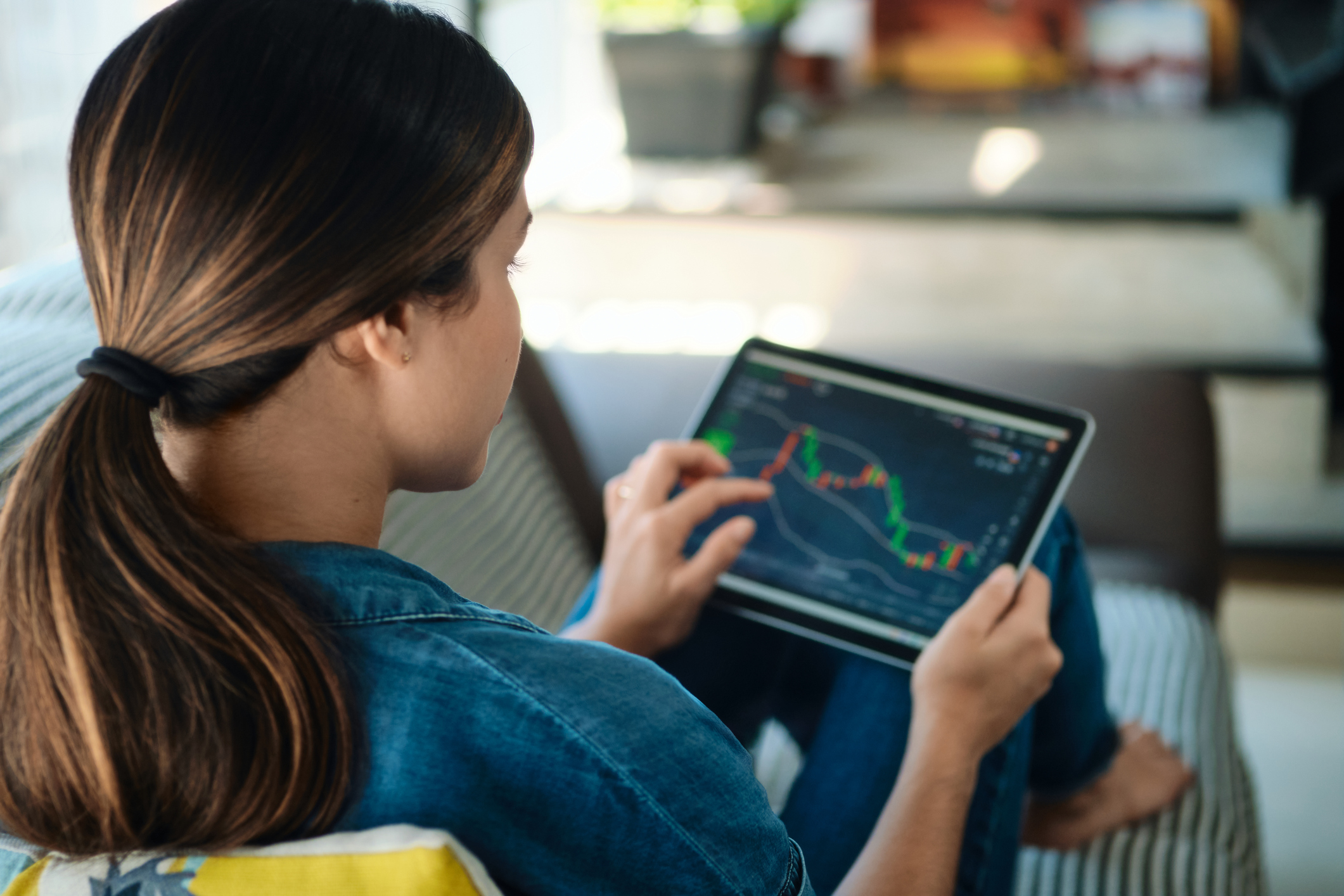 young_person_trading_on_tablet Person using a tablet to look at the performance of stocks.