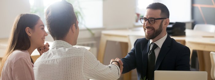 businessman shaking hands with couple