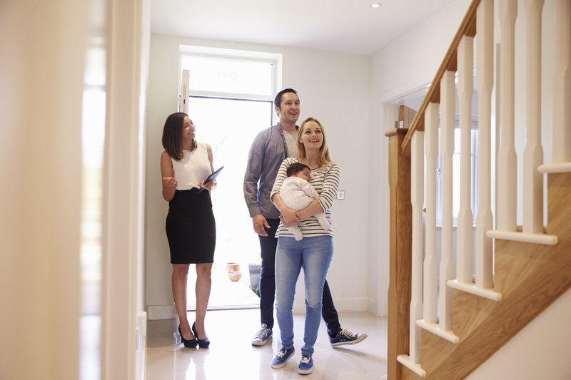 real estate agent showing a couple a house