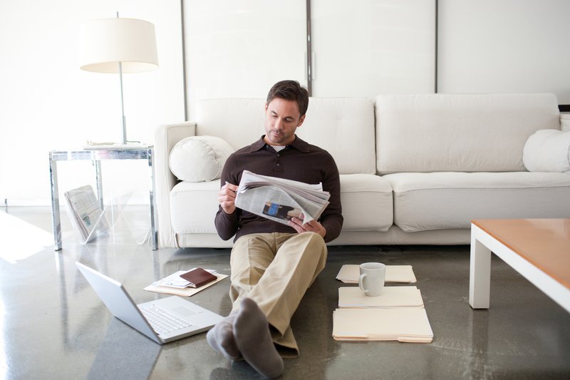 Man investing reading newspaper