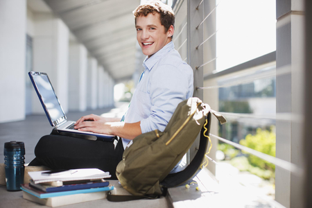 Man Sitting Down With A Laptop Smiling