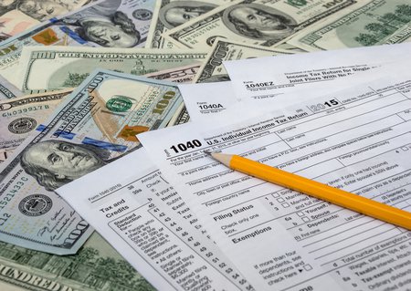 1040 tax form and dollar bills