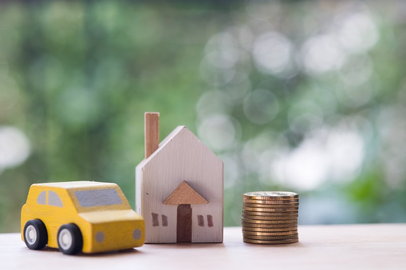 Small Car and House With Stack of Coins