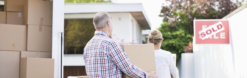 Older couple moving boxes from truck