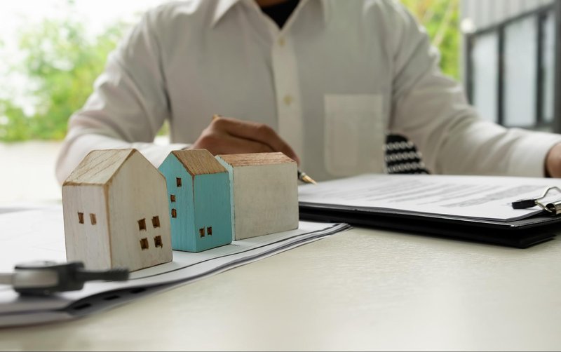 Person calculating finances with a house model
