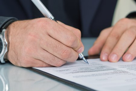 person in as suit signing in a contract