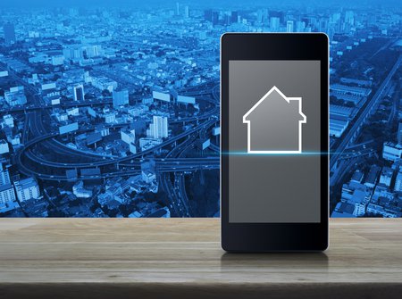phone showing a real estate search app in front of a city