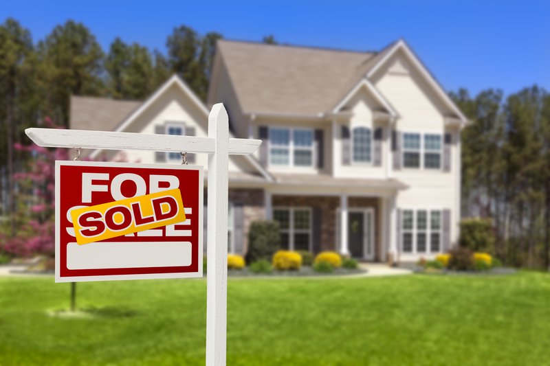 Single Family Home With Sold Sign Out Front