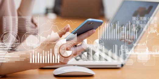 Stock market graphs on top of an image of a computer