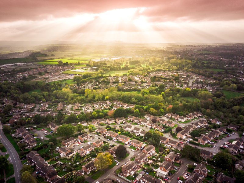 Sun bursting through clouds over countryside