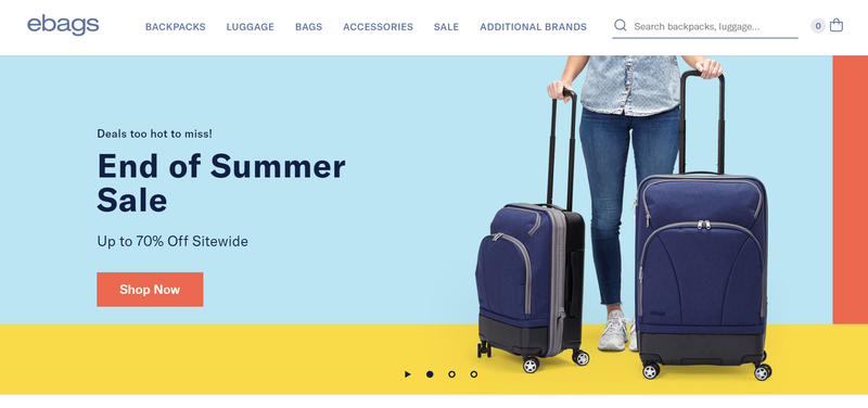 Summer sale promotion on a computer screen featuring a woman holding two suitcases.